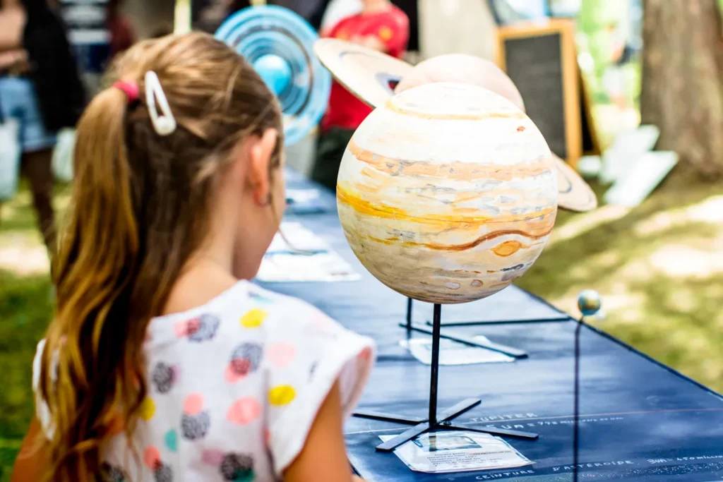 Petite fille observant une planète au Festival Astro Valberg