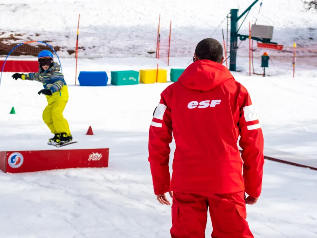 Moniteur et son élève en snowboard au club piou-piou à Valberg